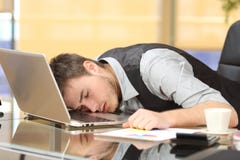 Müder Geschäftsmann, der über einem Laptop am Job schläft stockfotos Müder Geschäftsmann, der über einem Laptop am Job schläft stockfotos