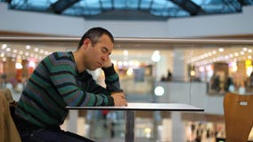 Müder Mann, der im Einkaufszentrum und im Café schläft stock footage Müder Mann, der im Einkaufszentrum und im Café schläft stock footage