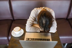 Müdes, erschöpftes Mädchen neben Laptop und Tasse Kaffee stockbilder Müdes, erschöpftes Mädchen neben Laptop und Tasse Kaffee stockbilder