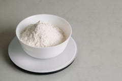 Mąka w pucharze jest na kuchennej skali obraz stock Mąka w pucharze jest na kuchennej skali obraz stock