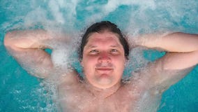 Mężczyzna kłama relaksuje w spojrzeniach przy kamerą i jacuzzi Kaukaski mężczyzna odpoczywa w basenie kłama na wodzie Widok zdjęcie wideo Mężczyzna kłama relaksuje w spojrzeniach przy kamerą i jacuzzi Kaukaski mężczyzna odpoczywa w basenie kłama na wodzie Widok zdjęcie wideo