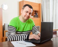 Mężczyzna obsiadanie przy pracą na laptopie zdjęcia stock Mężczyzna obsiadanie przy pracą na laptopie zdjęcia stock
