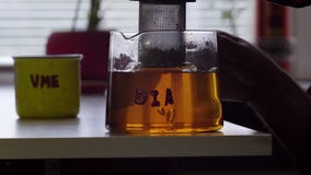Mężczyzna ręka podnosi w górę i stawia puszka herbacianego zbiornika szklany herbaciany garnek umieszczający na stole zbiory Mężczyzna ręka podnosi w górę i stawia puszka herbacianego zbiornika szklany herbaciany garnek umieszczający na stole zbiory