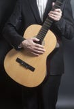 Mężczyzna w czarnym kostiumu z akustyczną klasyczną gitarą zdjęcia royalty free Mężczyzna w czarnym kostiumu z akustyczną klasyczną gitarą zdjęcia royalty free