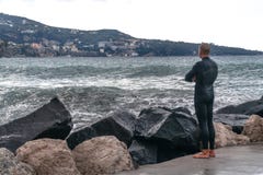 Mężczyzna w mokrym kostiumu, surfingowiec stoi na brzeg i patrzeje fale w tle góra, Sorrento Włochy zdjęcia stock Mężczyzna w mokrym kostiumu, surfingowiec stoi na brzeg i patrzeje fale w tle góra, Sorrento Włochy zdjęcia stock