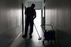 Mężczyzna z miotły cleaning biura korytarzem zdjęcie royalty free Mężczyzna z miotły cleaning biura korytarzem zdjęcie royalty free