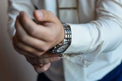 Mężczyzna załatwia jego cufflink w tux obraz royalty free Mężczyzna załatwia jego cufflink w tux obraz royalty free