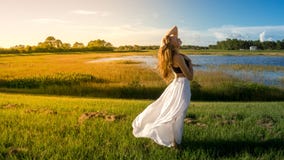 Młoda blondynki kobieta w krajobrazie z pokojową twarzą podczas zmierzch spódnicy włosy dmuchającego wiatrem Żółty miękki światło fotografia royalty free Młoda blondynki kobieta w krajobrazie z pokojową twarzą podczas zmierzch spódnicy włosy dmuchającego wiatrem Żółty miękki światło fotografia royalty free