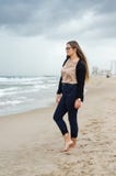 Młoda dziewczyna z szkłami pozuje na plaży na chmurnym dniu fotografia royalty free Młoda dziewczyna z szkłami pozuje na plaży na chmurnym dniu fotografia royalty free