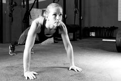Młoda kobieta robi pushups - crossfit trening obrazy stock Młoda kobieta robi pushups - crossfit trening obrazy stock