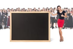 Młoda kobieta stoi blisko dużego chalkboard obrazy royalty free Młoda kobieta stoi blisko dużego chalkboard obrazy royalty free
