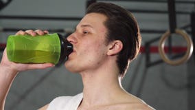 Młoda męska atleta uśmiecha się joyfully wodę pitną zdjęcia stock Młoda męska atleta uśmiecha się joyfully wodę pitną zdjęcia stock