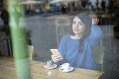 Młoda piękna kobieta pije kawę i używa jej smartphone siedzieć salowy w miastowej kawiarni Cukierniany miasto styl życia Przypadk zdjęcia royalty free Młoda piękna kobieta pije kawę i używa jej smartphone siedzieć salowy w miastowej kawiarni Cukierniany miasto styl życia Przypadk zdjęcia royalty free