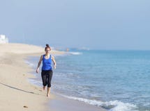 Młoda sprawności fizycznej kobieta jogging przy plażą obrazy royalty free Młoda sprawności fizycznej kobieta jogging przy plażą obrazy royalty free