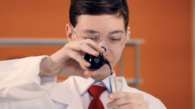 Młoda szkolna chłopiec miesza ciecze w próbnej tubce w nauki klasie zbiory wideo Młoda szkolna chłopiec miesza ciecze w próbnej tubce w nauki klasie zbiory wideo