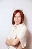 Młoda uśmiechnięta czerwona z włosami dziewczyna w złocistym obręczu z ucho, trykotowy beżowy pulower na białym tle patrzeje kame zdjęcie stock Młoda uśmiechnięta czerwona z włosami dziewczyna w złocistym obręczu z ucho, trykotowy beżowy pulower na białym tle patrzeje kame zdjęcie stock