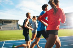 Młode atlety biega na biegowym śladzie w stadium obraz royalty free Młode atlety biega na biegowym śladzie w stadium obraz royalty free