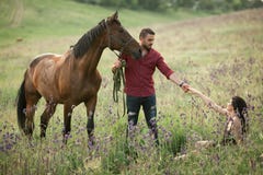 Młodego człowieka stojaki obok konia i trzymają za jego ręce kobieta zdjęcie royalty free Młodego człowieka stojaki obok konia i trzymają za jego ręce kobieta zdjęcie royalty free