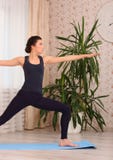 Młodej atrakcyjnej kobiety ćwiczy joga po budzić się up ćwiczy out, Virabhadrasana II poza, pracująca, ind, stojący w wojowniku D zdjęcie stock Młodej atrakcyjnej kobiety ćwiczy joga po budzić się up ćwiczy out, Virabhadrasana II poza, pracująca, ind, stojący w wojowniku D zdjęcie stock