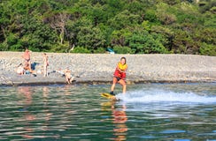 Młodej kobiety wakeboarder sunięcia na płaskiej morze powierzchni holującej wakeboard motorową łodzią przy zmierzchem obraz royalty free Młodej kobiety wakeboarder sunięcia na płaskiej morze powierzchni holującej wakeboard motorową łodzią przy zmierzchem obraz royalty free