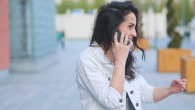Młodociana atrakcyjna brązowowłosa caucasian dziewczyna opowiada na telefonie w białym cajgu żakiecie i czarnej koszulce, wiatrow zbiory Młodociana atrakcyjna brązowowłosa caucasian dziewczyna opowiada na telefonie w białym cajgu żakiecie i czarnej koszulce, wiatrow zbiory
