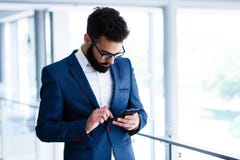 Młody biznesmen Używa telefon komórkowego Przy miejscem pracy zdjęcia stock Młody biznesmen Używa telefon komórkowego Przy miejscem pracy zdjęcia stock