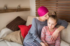 Młody dorosłej kobiety pacjent z nowotworem wydaje czas z jej córką w domu na leżance, relaksujący Nowotwór i rodzinny poparcie obrazy stock Młody dorosłej kobiety pacjent z nowotworem wydaje czas z jej córką w domu na leżance, relaksujący Nowotwór i rodzinny poparcie obrazy stock