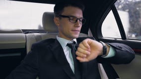 Młody niespokojny biznesmen dla lota póżno, patrzejący zegarek, ruch drogowy w mieście zdjęcie wideo Młody niespokojny biznesmen dla lota póżno, patrzejący zegarek, ruch drogowy w mieście zdjęcie wideo