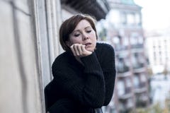 Młody piękny kobiety główkowanie i uczucia cierpienia smutna depresja przy miastowym miasta tłem stwarzamy ognisko domowe balkon obraz stock Młody piękny kobiety główkowanie i uczucia cierpienia smutna depresja przy miastowym miasta tłem stwarzamy ognisko domowe balkon obraz stock