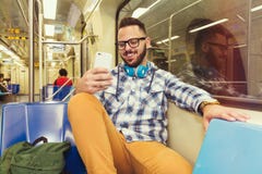 Młody podróżnik jest ubranym szkockiej kraty koszula czyta zabaw karmy na ogólnospołecznych sieci stronach na telefonie komórkowy fotografia royalty free Młody podróżnik jest ubranym szkockiej kraty koszula czyta zabaw karmy na ogólnospołecznych sieci stronach na telefonie komórkowy fotografia royalty free