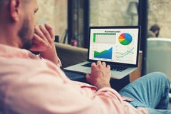 Młody przedsiębiorca analizuje występ na jego notatniku obrazy stock Młody przedsiębiorca analizuje występ na jego notatniku obrazy stock