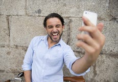 Młody szczęśliwy mężczyzna bierze selfie z telefonem komórkowym na retro chłodno rocznika rowerze Zdjęcie Stock Młody szczęśliwy mężczyzna bierze selfie z telefonem komórkowym na retro chłodno rocznika rowerze Zdjęcie Stock