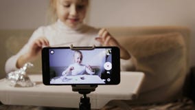Młody, śmieszny dziewczyny blogger, robi rejestrowi zagadnienie Dziecko odpakowywa jajko z niespodzianką zdjęcie wideo Młody, śmieszny dziewczyny blogger, robi rejestrowi zagadnienie Dziecko odpakowywa jajko z niespodzianką zdjęcie wideo