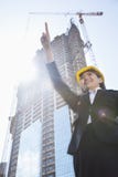 Młody żeński architekt wskazuje przy budową zdjęcia stock Młody żeński architekt wskazuje przy budową zdjęcia stock
