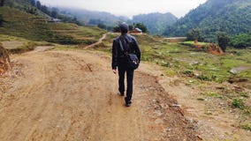 M?odzi facet?w spacery wzd?u? drogi w?r?d ry? tarasuj? w wiosce kot kat blisko miasta Sapa Wietnam zbiory M?odzi facet?w spacery wzd?u? drogi w?r?d ry? tarasuj? w wiosce kot kat blisko miasta Sapa Wietnam zbiory
