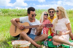 Młodzi ludzie słucha faceta bawić się gitara przyjaciół grupowego letniego dzień fotografia stock Młodzi ludzie słucha faceta bawić się gitara przyjaciół grupowego letniego dzień fotografia stock
