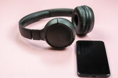 N?rbild av den smarta telefonen med h?rlurar p? en rosa bakgrund royaltyfri bild N?rbild av den smarta telefonen med h?rlurar p? en rosa bakgrund royaltyfri bild