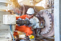 Na morzu wieża wiertnicza pracownik, Machinalny technik sprawdza nafcianą odśrodkową pompę zdjęcie stock Na morzu wieża wiertnicza pracownik, Machinalny technik sprawdza nafcianą odśrodkową pompę zdjęcie stock