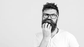 Nachdenklicher Mann, der seinen Bart auf weißer Wand berührt Gut aussehender Mann in den Gläsern denkt Emotionaler bärtiger Kerl lizenzfreie stockbilder Nachdenklicher Mann, der seinen Bart auf weißer Wand berührt Gut aussehender Mann in den Gläsern denkt Emotionaler bärtiger Kerl lizenzfreie stockbilder
