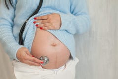 Nacimientos hermosos del estetoscopio de la medicina del estómago de la mujer embarazada foto de archivo Nacimientos hermosos del estetoscopio de la medicina del estómago de la mujer embarazada foto de archivo