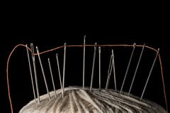Nadeln und orange Baumwolle verlegt auf einer weißen Baumwollschrittballmakronahaufnahme Lizenzfreie Stockfotografie Nadeln und orange Baumwolle verlegt auf einer weißen Baumwollschrittballmakronahaufnahme Lizenzfreie Stockfotografie