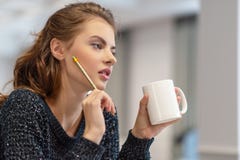 Nadenkende jonge vrouw die nota's maken die blocnote in keuken gebruiken royalty-vrije stock foto Nadenkende jonge vrouw die nota's maken die blocnote in keuken gebruiken royalty-vrije stock foto