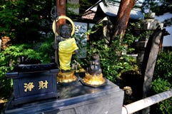 Black Buddha and praying raccoon statue at the entrance of the Zenko-ji temple in Japan royalty free stock photos Black Buddha and praying raccoon statue at the entrance of the Zenko-ji temple in Japan royalty free stock photos