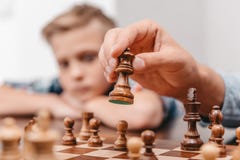 Nahaufnahme der männlichen Hand eine Schachfigur über a halten Lizenzfreies Stockfoto Nahaufnahme der männlichen Hand eine Schachfigur über a halten Lizenzfreies Stockfoto