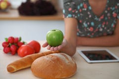 Nahaufnahme der weiblichen Hand grünen Apfel im Kücheninnenraum halten Viel Gemüse und andere Mahlzeit am Glastisch sind stockbilder Nahaufnahme der weiblichen Hand grünen Apfel im Kücheninnenraum halten Viel Gemüse und andere Mahlzeit am Glastisch sind stockbilder