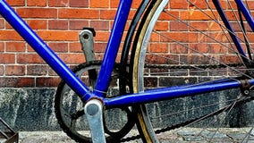 Nahaufnahme eines blauen Fahrrades auf einem Wandhintergrund der roten Backsteine - Fahrradkettendetail stockfoto Nahaufnahme eines blauen Fahrrades auf einem Wandhintergrund der roten Backsteine - Fahrradkettendetail stockfoto