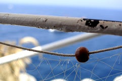 Nahaufnahme eines Fischernetzfalles auf einem weißen Pfosten auf einem Schiff an der Küste mit einem blauen Hintergrund lizenzfreies stockfoto Nahaufnahme eines Fischernetzfalles auf einem weißen Pfosten auf einem Schiff an der Küste mit einem blauen Hintergrund lizenzfreies stockfoto
