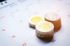 Nahaufnahme von Geldstapeln des thail?ndischen Baht auf einem Druckkalender mit Zahlen in Schwarzem und in Rotem auf schwarzem Hi stockfotografie Nahaufnahme von Geldstapeln des thail?ndischen Baht auf einem Druckkalender mit Zahlen in Schwarzem und in Rotem auf schwarzem Hi stockfotografie