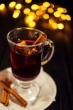 Nahaufnahmeglas Glühwein mit Orange und Zimt auf dunklem schwarzem Hintergrund, auf weißer Platte, Weihnachtslichter, großes Gelb stockbilder Nahaufnahmeglas Glühwein mit Orange und Zimt auf dunklem schwarzem Hintergrund, auf weißer Platte, Weihnachtslichter, großes Gelb stockbilder