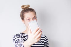 Nahaufnahmeporträt von den schönen attraktiven lächelnden Blondinen, die selfie auf Smartphone auf Weiß nehmen lizenzfreies stockfoto Nahaufnahmeporträt von den schönen attraktiven lächelnden Blondinen, die selfie auf Smartphone auf Weiß nehmen lizenzfreies stockfoto